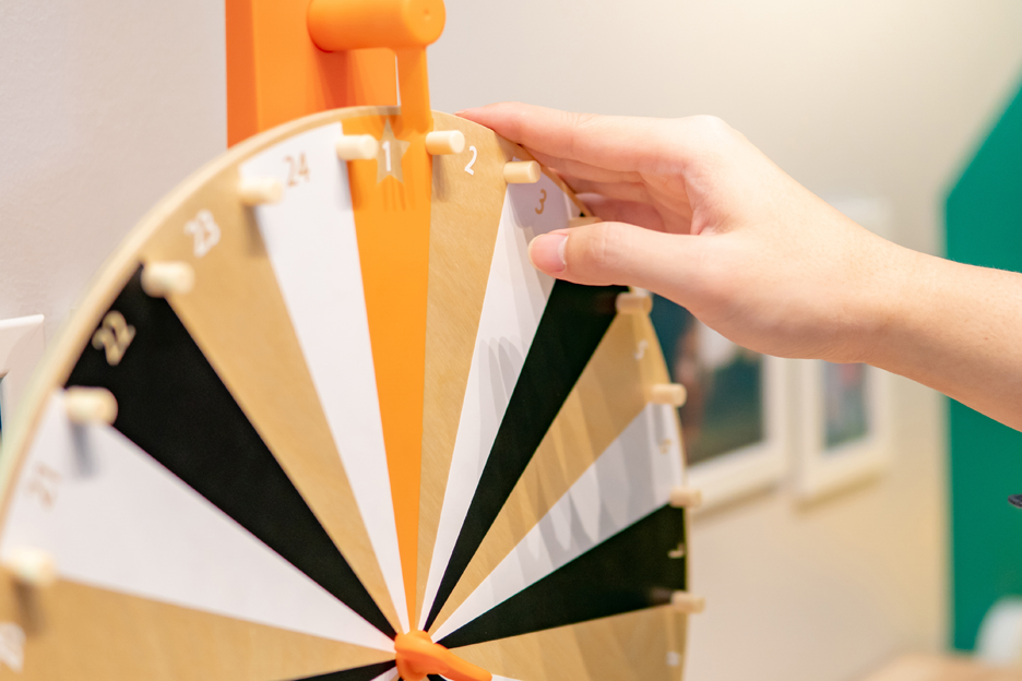 Hand spinning wooden wheel of fortune game at trade show.